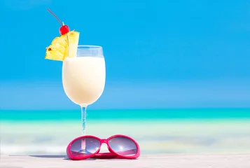 Rolgordijnen picture of pina colada and sunglasses on tropical beach © el.rudakova