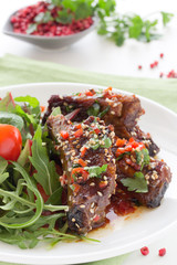 Pork ribs in ginger glaze with salad.