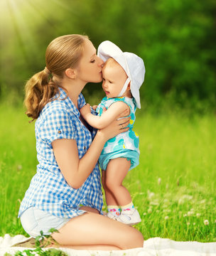 happy family on a walk. mother kissing baby