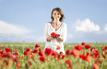 Fototapeta na wymiar Casual woman relaxing in poppy field