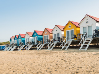 Row of colorful beach huts in the sand