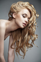 Naklejka premium Sensual woman with shiny curly long blond hair