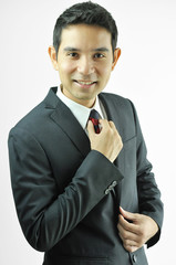 Smiling businessman holding  necktie