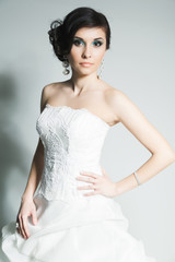 Studio portrait of young bride in stylish white dress