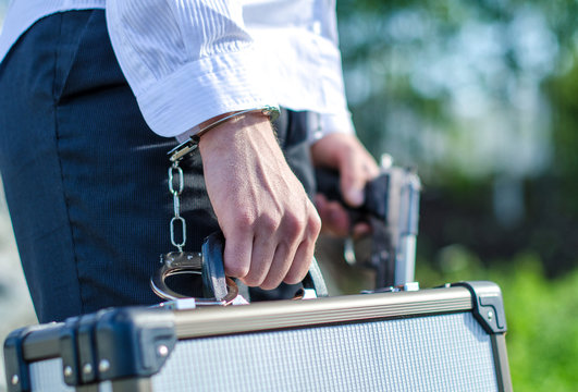 Close up view of male hand enchained to suitcase