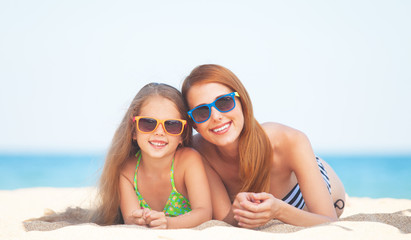 Beautiful mother and little daughter at tropical beach