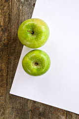 Green apples and white paper