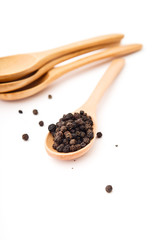 Black pepper on wood spoon