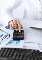 woman hand with calculator and papers