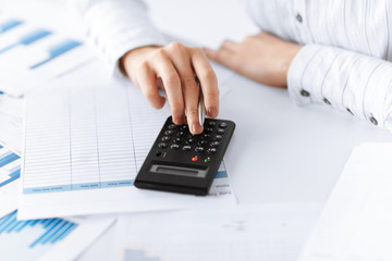 woman hand with calculator and papers