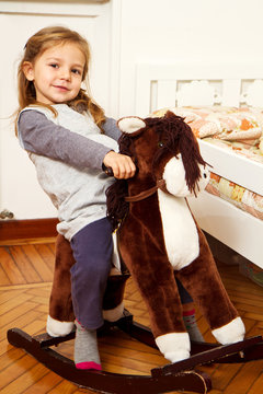 bambina su cavallo a dondolo