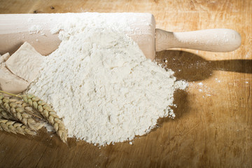 Pile of flour, rolling pin and wheat