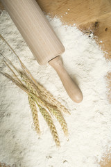 Pile of flour, rolling pin and wheat