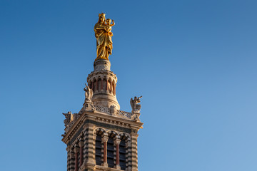 Fototapeta na wymiar Golden Statue of the Madonna Holding the little Jesus on the top