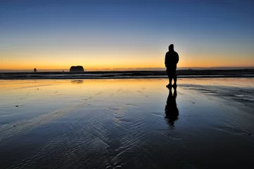 Rolgordijnen Lone Man walking alongside the beach © mohdnadlyaizat