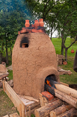 clay stove with whole fire woods burning on it