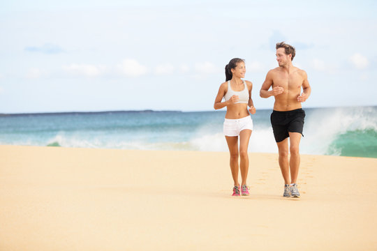 Running people - runners couple on beach run
