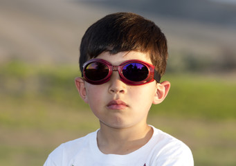 Boy wears colored goggles.