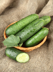 Tasty green cucumbers on sackcloth background
