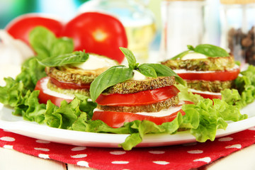 Tasty roasted marrow and tomato slices with salad leaves,