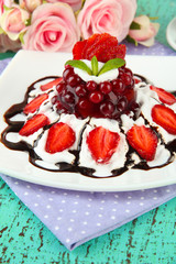 Tasty jelly dessert with fresh berries, on pink roses