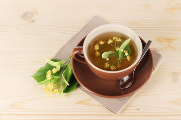 Cup of tea with linden on napkin   wooden table