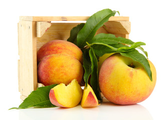 Ripe sweet peaches in wooden crate, isolated on white