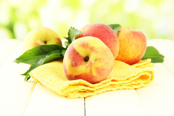 Ripe sweet peaches on wooden table in garden, close up