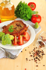 Piece of fried meat on plate on wooden table close-up