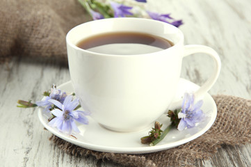 Cup of tea with chicory, on wooden background
