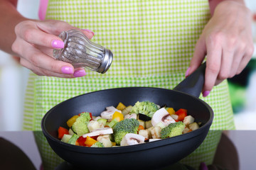 Hands cooking vegetable ragout in pan in kitchen