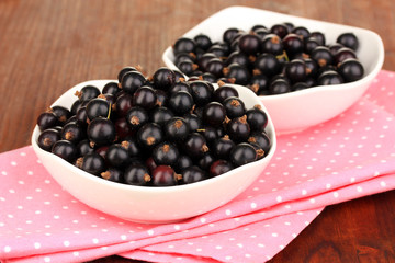 Fresh black currant on wooden background