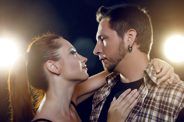 Beautiful young couple in love. The girl embraces the guy's neck