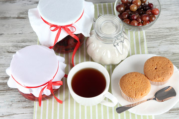 Yummy jam in banks on napkin on wooden table