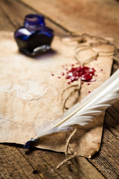 Closeup of a feather lying on old sheet of paper