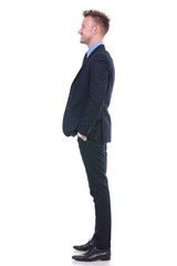 business man stands sideways and smiles