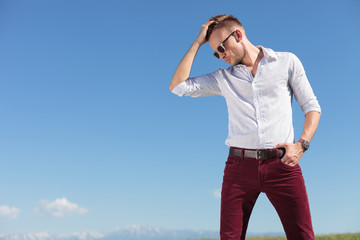 casual man fixes his hair outdoors