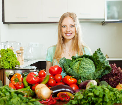 happy woman with pile of raw vegetables