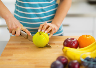 Closeup on young woman cutting apple