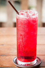 Glass of cold red drink with straw