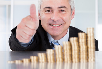 Businessman With Coins Showing Thumbs Up Sign