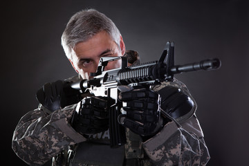 Portrait Of A Mature Soldier Aiming With Gun
