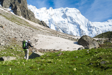 Fototapeta na wymiar Hikier is climbing mountain in Caucasus mountains in Bezengi reg