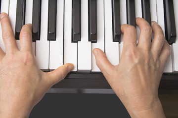 Two hands playing on the piano