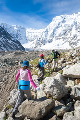 Hikiers are approaching wall covered with snow in Caucasus mount