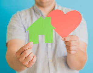 Obraz premium heart and a small house in the hands of