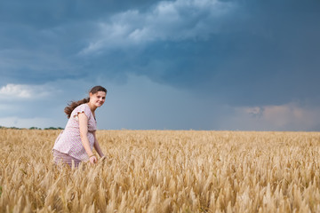Naklejka na ściany i meble Young pregnant woman on wheat field