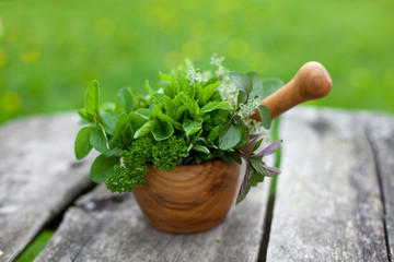 fresh herbs in a wooden mortar