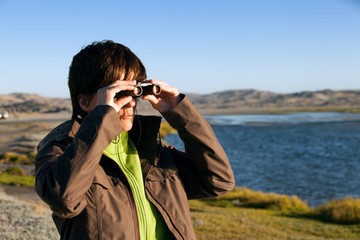woman with binoculars scanning the horizon