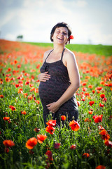 Pregnant woman in a flowering poppy field
